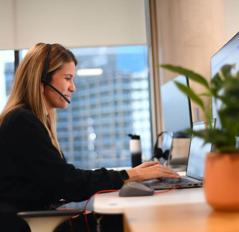 An image of some one using a headset at a desk.